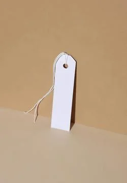 Blank white tag with string on beige background Stock Photos