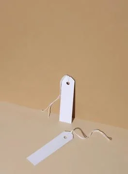 Blank white tags with string on beige background Stock Photos