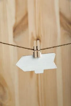 Blank wooden arrow pointer hang with clothespins on rope on wooden background Stock Photos