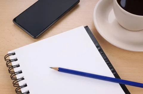 Blank writing pad on desk empty writing or note pad with pencil, smart pho... Stock Photos