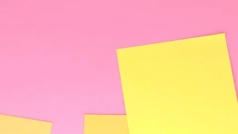 Blank yellow note paper and post-it notes and stickers fall on pink desktop.. Foto stock