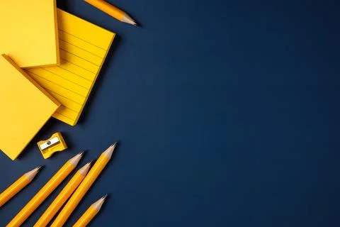 Blank yellow sticky note and pencil on navy blue table background Stock Photos