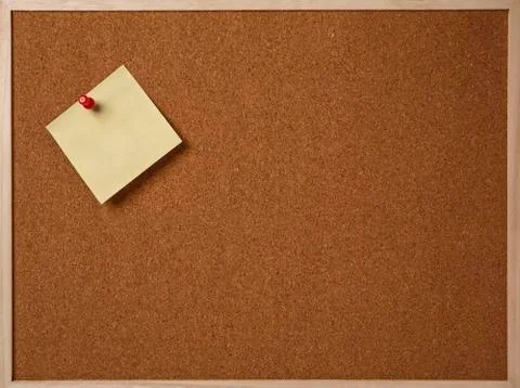 Blank yellow sticky note pinned on a cork bulletin board Stock Photos