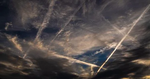 Blanketed layers of clouds with contrails that slash like white-hot blades. Stock-Fotos