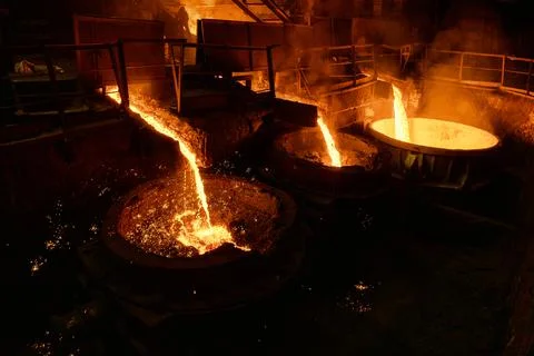 Blast furnace slag and pig iron tapping. Molten metal and slag are poured into a Stock Photos