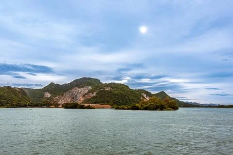 Blasting Mountains. View of mountain rock quarry by river under overcast sk.. 스톡 사진