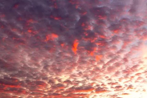 Blazing clouds against the backdrop of the setting sun Stock Photos