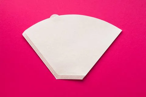 Bleached paper coffee filter for immersion brewing isolated on a colored pink Photos