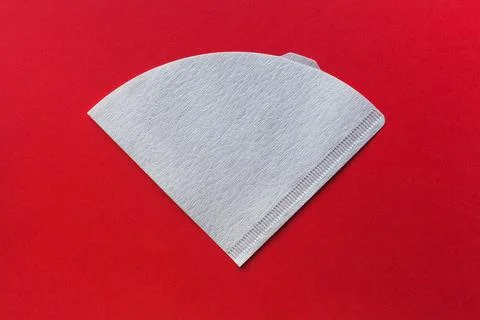 Bleached paper coffee filter isolated on red background Photos