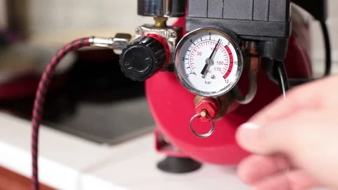 Bleeding of air from the receiver of compressor, close-up view with hand and man Stock Footage 100078491