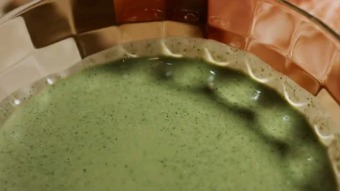 Blend pancake batter and fresh spinach leaves in a glass bowl. Process of Stock Footage 144903269