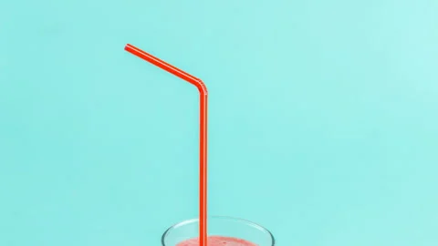Blended pink drink with staw. nuts and berries on the blue table Stock Footage 101337562