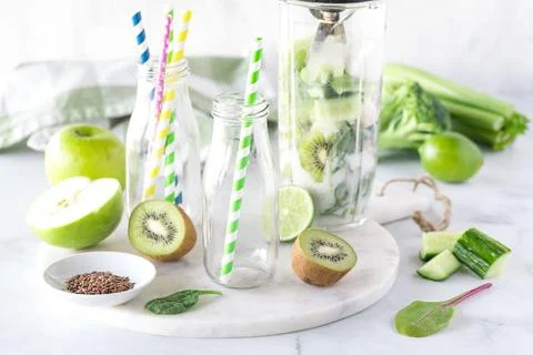 A blender container filled with green ingredients to make a green smoothie. Stock Photos