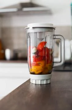 Blender with fresh vegetables on kitchen table Stock Photos