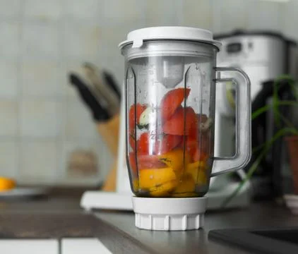 Blender with fresh vegetables on kitchen table Stock Photos