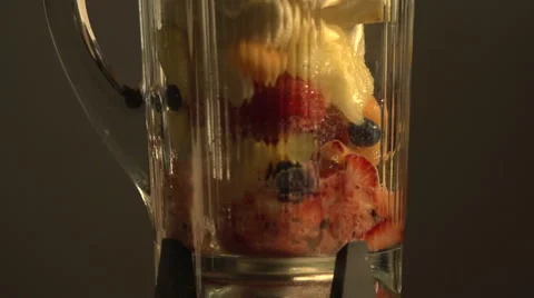 A blender full of fruit begins to operate - slow motion Stock Footage 44116971