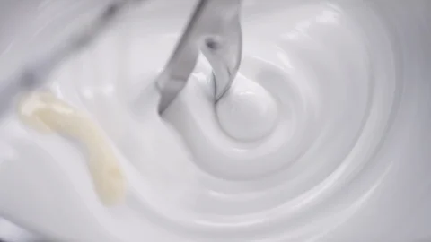 Blender whiskes white cream while beige liquid is added in the laboratory Stock Footage 100748507