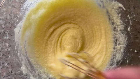 Blending Creamy Yellow Cake Batter with a Wire Whisk Stock Footage 345522286