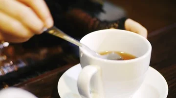 Blending tea with a spoon in a mug Stock Footage 86099557