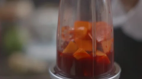 Blending together mango and red juice, blender smoothie Stock Footage 194478571