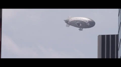 Blimp flying behind building Vidéo 56949648