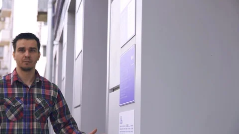 Blind guy on the street reading a braille font on a building sign Stock Footage 89080155