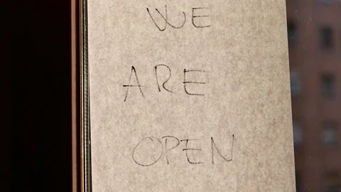 A blind is lifted and the label 'WE ARE OPEN' Stock Footage 80368350