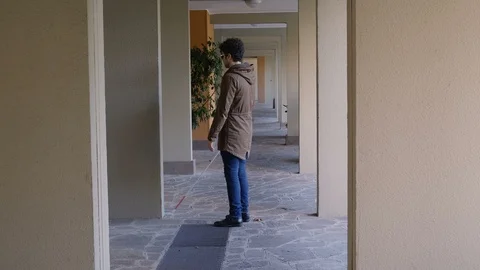 Blind man alone using his stick to orientate himself in entrance hall  Video stock 120023952