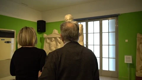 A blind man and his guide walk towards a copy of the Aphrodite de Milo 스톡 동영상 140992042
