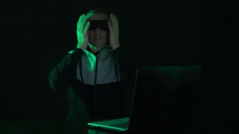 A blind man in front of a laptop computer is blind, blindfolded looking for a Stock Footage 123169815