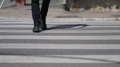 Blind man navigating crosswalk with cane on busy street Stock Footage 285527370