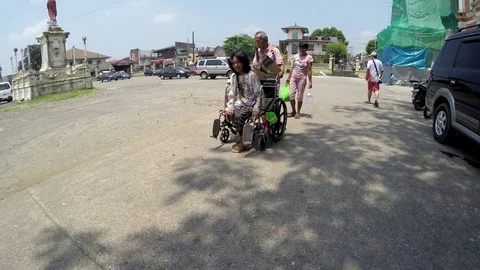 Blind man pushing wheelchair of disabled beggar Stock Footage