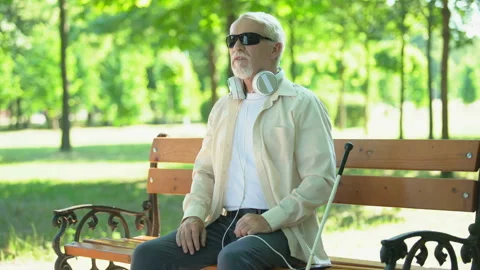 Blind man quickly putting on headphones, answering incoming call, voice message Stock-Footage 113530356