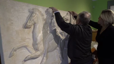 Blind man touching a copy of one of the parthenon marbles Stock Footage 140992530