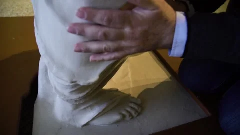Blind man touching the legs and feet of a copy of the statue Venus de Milo a Stock Footage 140985500