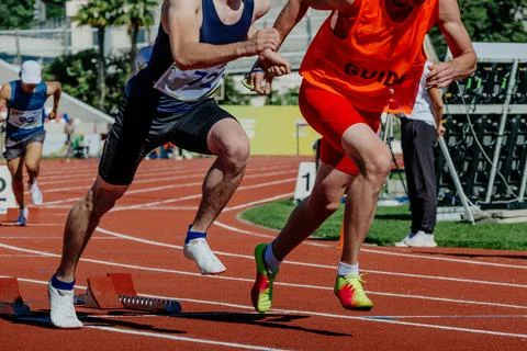 Blind para athlete runner with guide in starting blocks running race Foto stock