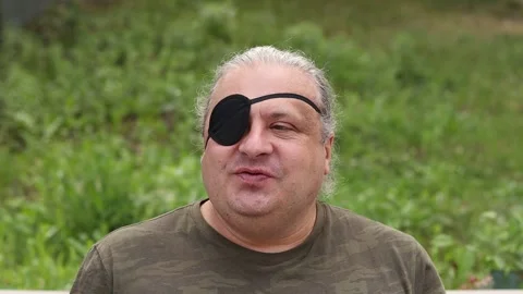 A blind, visually impaired man with a black medical patch on his eye looks at Vídeos de archivo 279002162