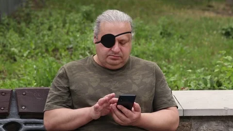 A blind, visually impaired man with a black medical patch on his eye looks at Stock Footage 279002205