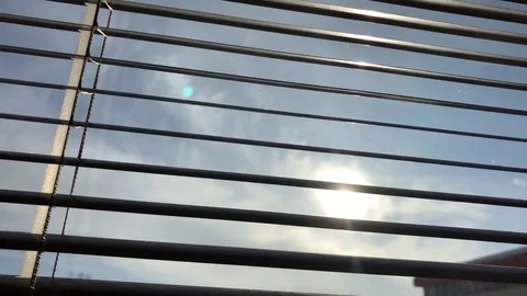 Blind on the window is being opened and the sun is shining through it Stock Footage 84913022