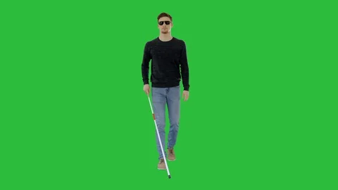 Blind young man with stick walking on a Green Screen, Chroma Key. Vídeos de archivo 129246033