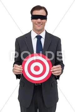 Blindfolded and smiling businessman holding a red target Stock Photos