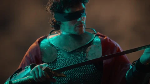 Blindfolded Knight in Armor Holding Glowing Magical Sword Stock Footage 345511902