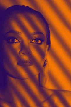 Blinds casts shadow on beautiful model with smokey make-up face studio portra Stock Photos