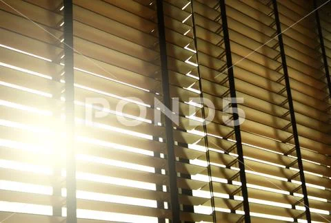 Blinds in a home catching the sunlight with burst light Stock Photos