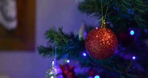 Blinking blue lights on a christmas tree between hanging decorative bubbles Stock Footage 150681356