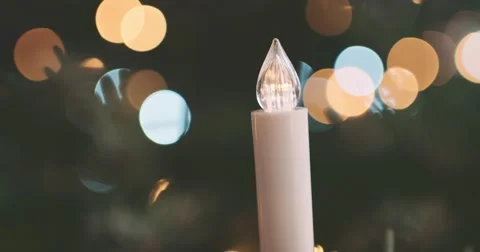 Blinking Electric Candle in front of Christmas Lights. 4K SLOW MOTION 120 fps Stock Footage 67219728