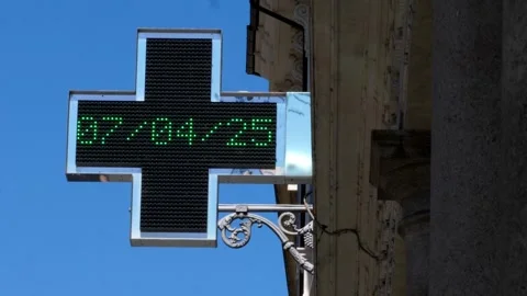 Blinking green cross of a pharmacy with blue sky in the background Stock Footage 306320394