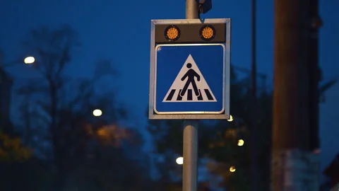 Blinking illuminated pedestrian crossing sign at dusk with glowing amber li.. Stock Footage 332280003