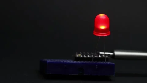 Blinking LED on breadboard controlled by a programmable microcontroller 動画素材 336626479