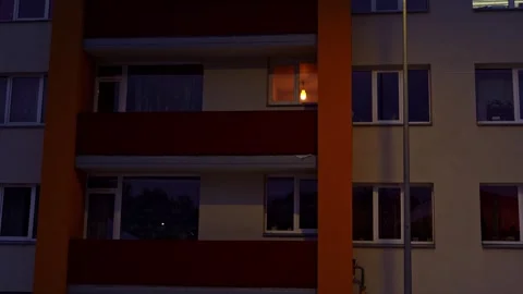 Blinking light bulb in an apartment window of a residential building at night Stock Footage 342761562